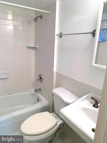 a white toilet and tub sitting next to a bathroom sink