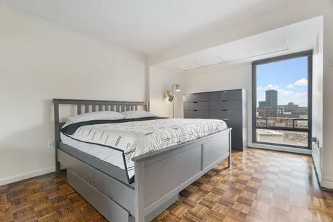 a bed sitting in a bedroom next to a window