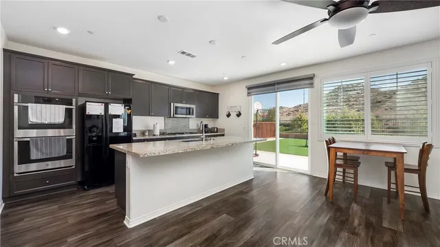 a kitchen with stainless steel appliances granite countertop a stove and a wooden floors