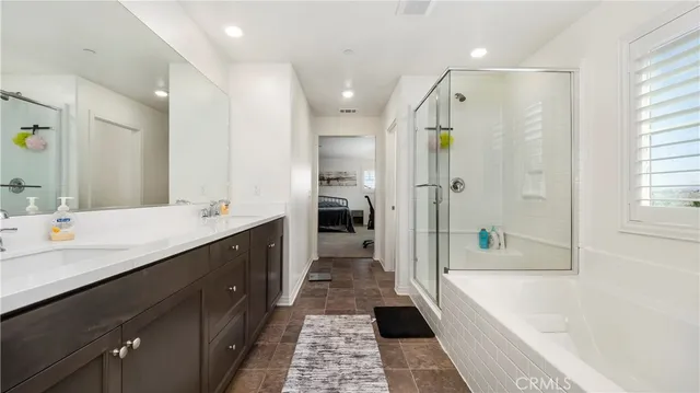 a bathroom with a large tub shower vanity and a sink