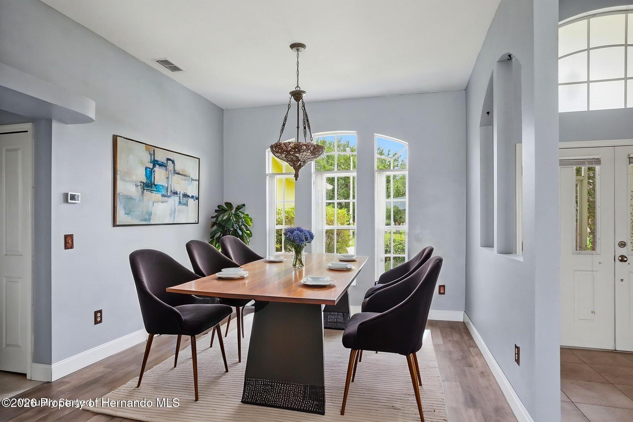 18131 Rivard Boulevard Brooksville, FL 34604 - Photo 24 of 66 a dining room with furniture a chandelier and wooden floor