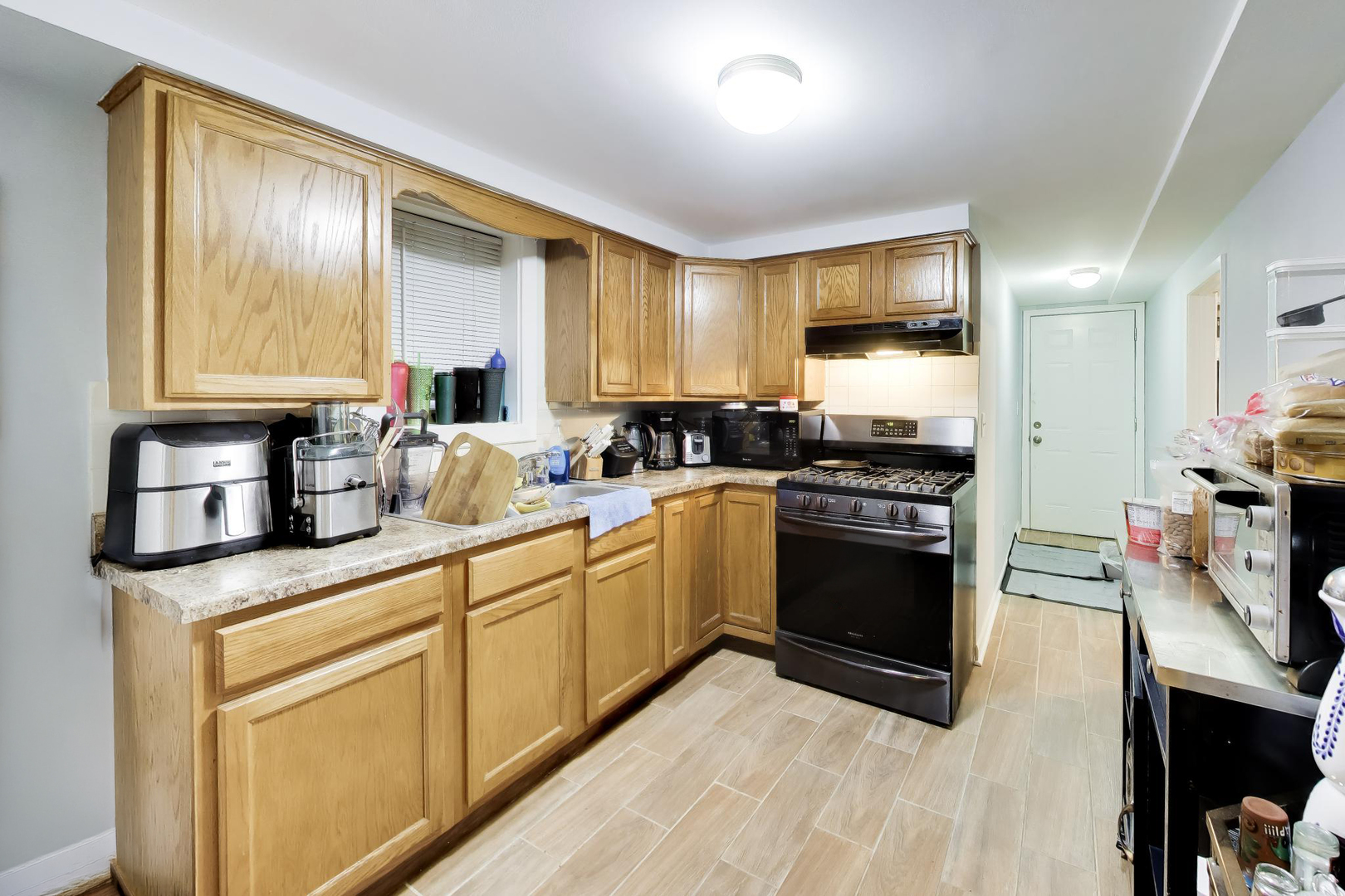5057 West Dakin Street, Unit G Chicago, IL 60641 - Photo 12 of 19 a kitchen with stainless steel appliances granite countertop a stove a sink and a refrigerator
