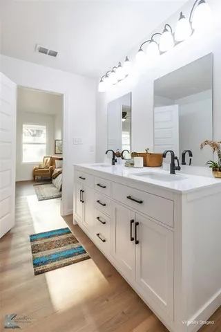 a en suite bathroom with double sink and a mirror
