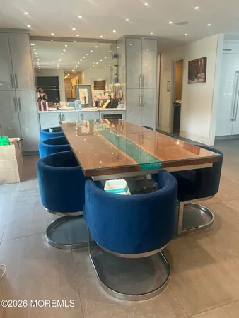 a room with wooden floor pool table and chairs