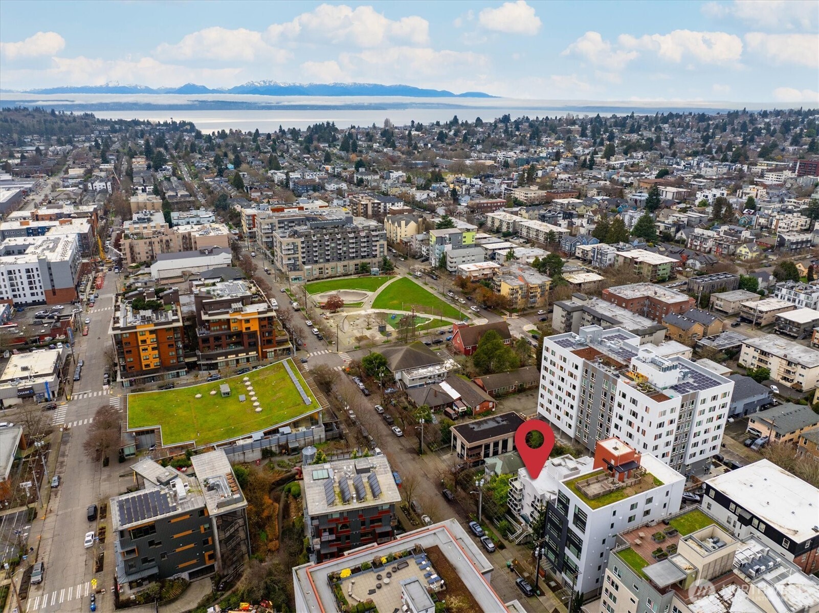 2024 Northwest 57th Street, Unit 201 Seattle, WA 98107 - Photo 27 of 29 an aerial view of a city with lots of residential buildings ocean and mountain view in back