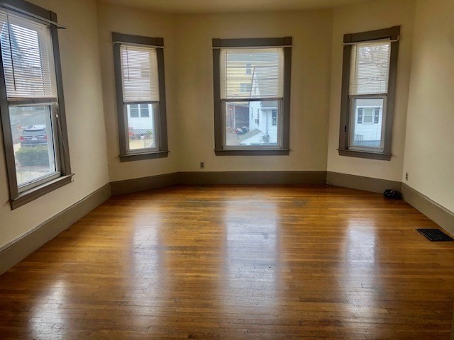 233 Washington Street, Unit 2 Malden, MA 02148 - Photo 2 of 13 a view of an empty room with wooden floor and windows