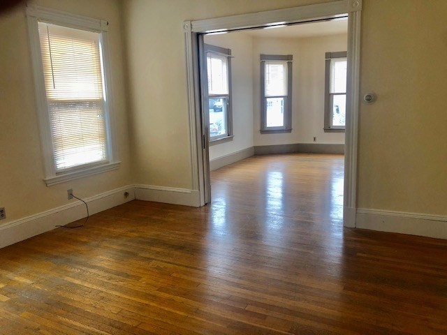 233 Washington Street, Unit 2 Malden, MA 02148 - Photo 3 of 13 an empty room with wooden floor and windows