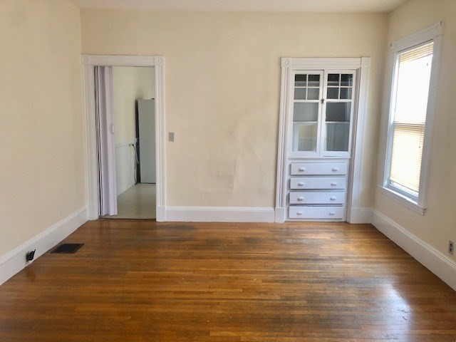 233 Washington Street, Unit 2 Malden, MA 02148 - Photo 5 of 13 an empty room with wooden floor and windows