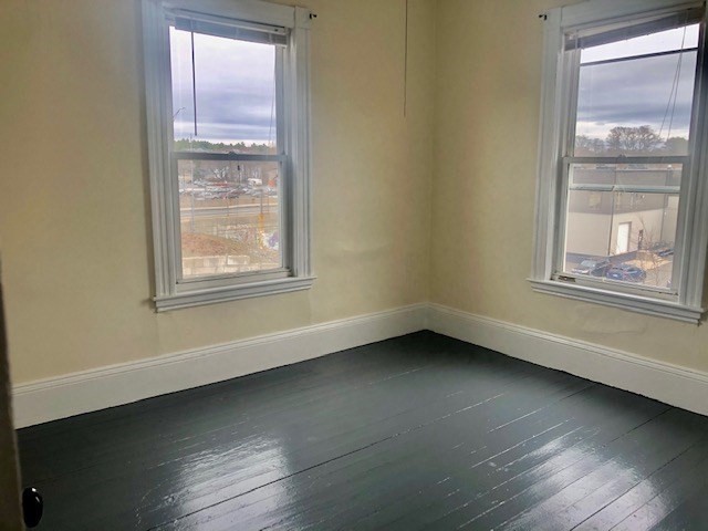 233 Washington Street, Unit 2 Malden, MA 02148 - Photo 9 of 13 an empty room with wooden floor and windows