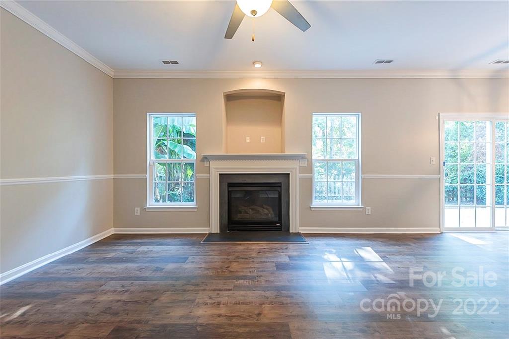 7632 Black Hawk Lane Tega Cay, SC 29708 - Photo 3 of 16 wooden floor fireplace and windows in an empty room