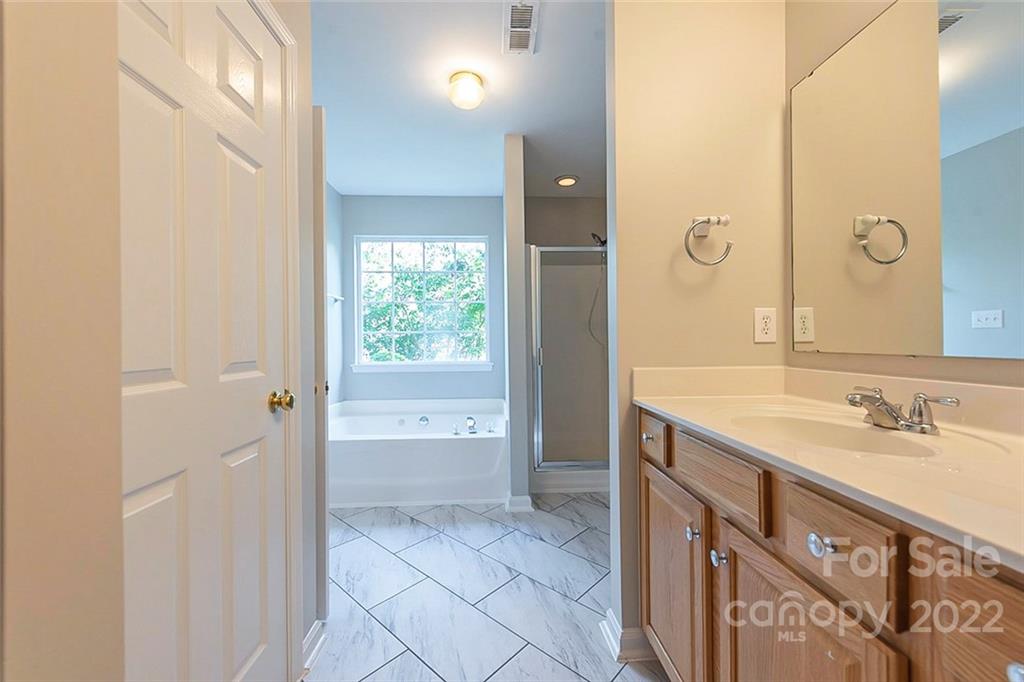 7632 Black Hawk Lane Tega Cay, SC 29708 - Photo 7 of 16 a bathroom with a granite countertop sink a mirror and a bathtub