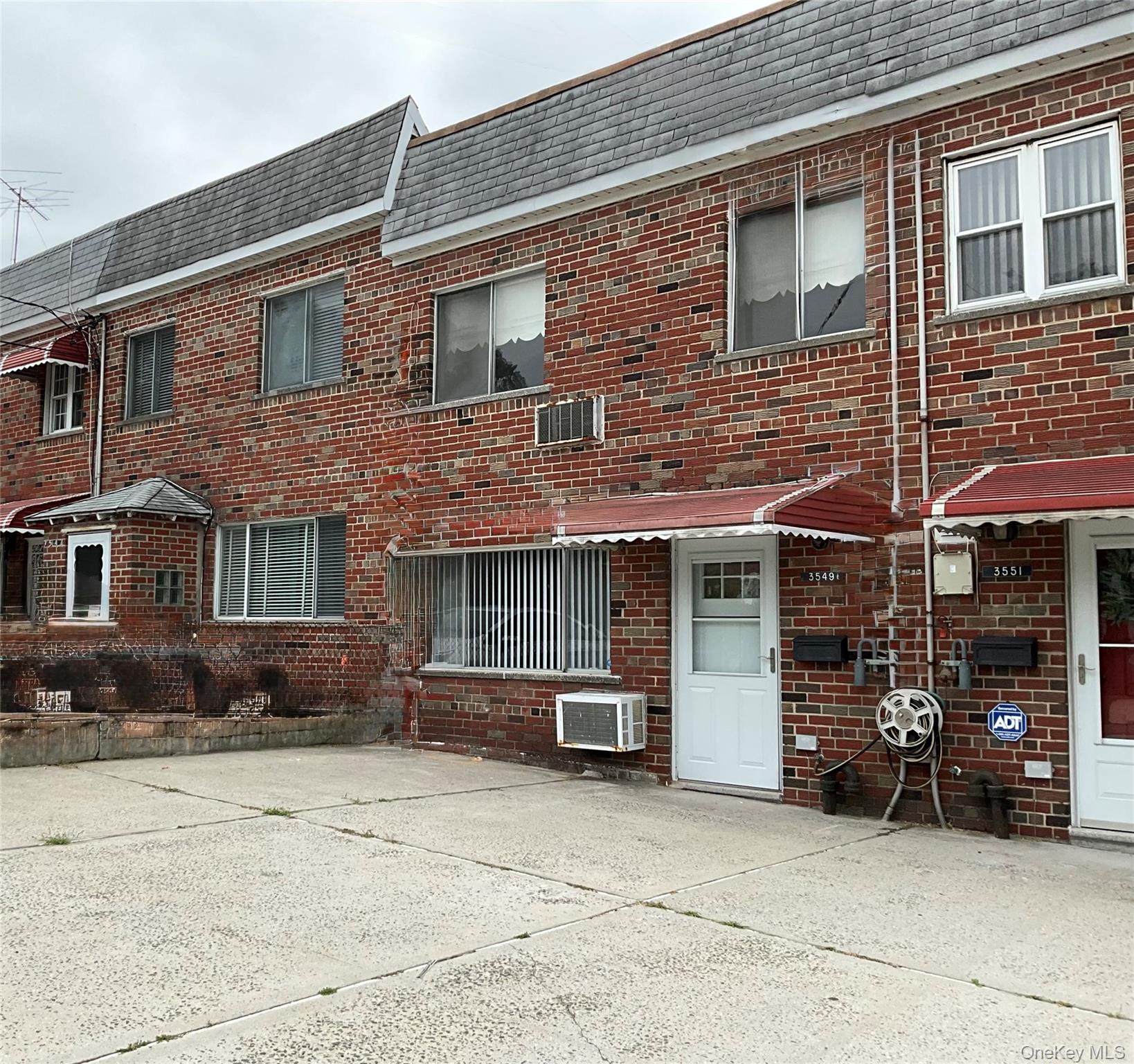 View of front of house with brick siding and mansard roof