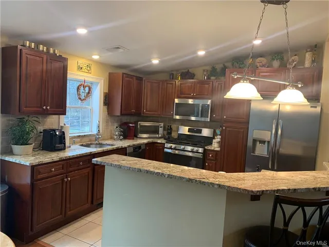 a kitchen with stainless steel appliances granite countertop a sink a stove and cabinets