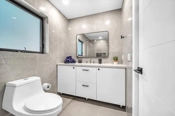 a bathroom with a toilet sink and mirror