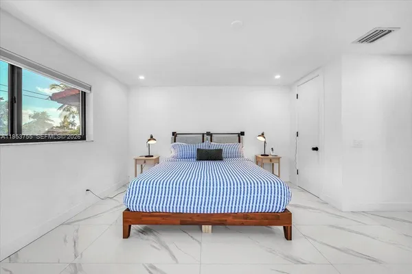 a bedroom with a bed and painting on the wall