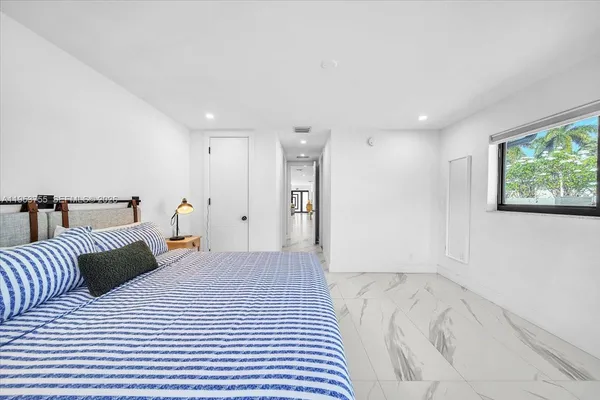 a bedroom with a large bed and a chandelier