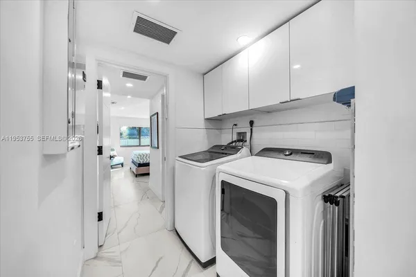 a view of washer and dryer with kitchen in the background