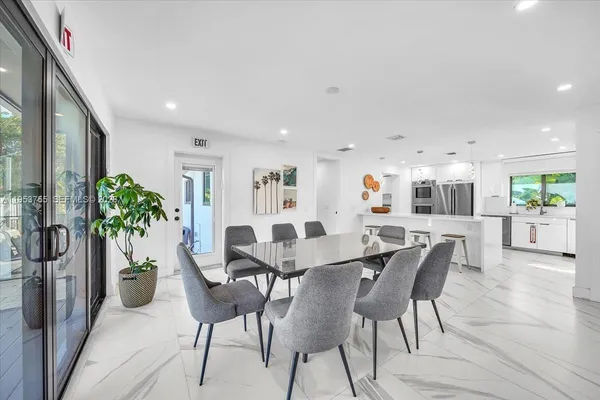 a view of a dining room with furniture and a potted plant