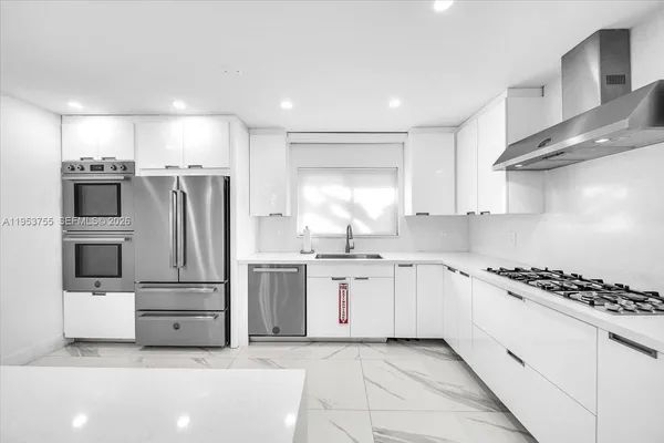 a kitchen with stainless steel appliances a refrigerator sink and stove top oven