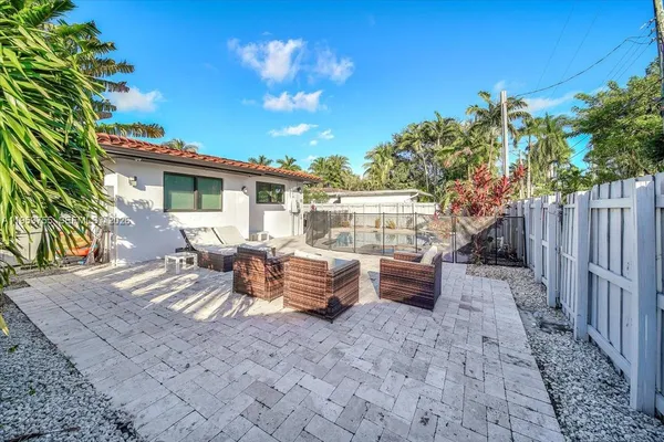 a view of a patio with couches and table and chairs and potted plants