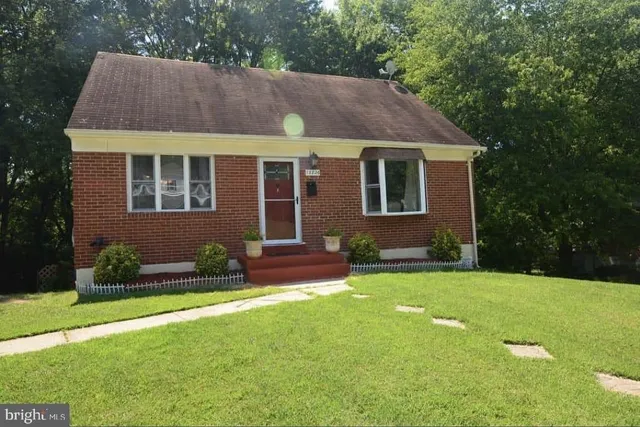 a front view of a house with a yard and potted plants