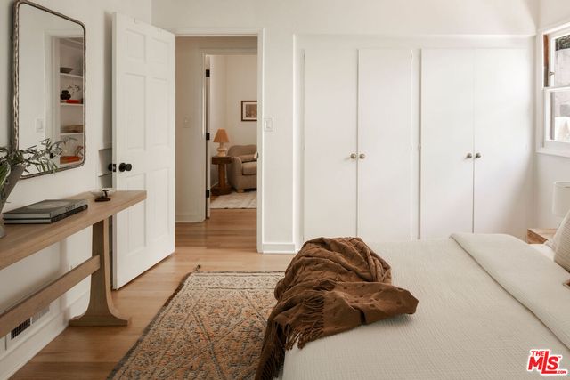 a living room with a bed a couch and a dresser