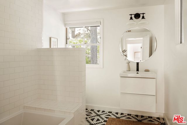 a bathroom with a sink a mirror and shower