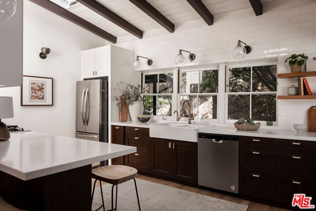 a kitchen with stainless steel appliances granite countertop a sink a stove a refrigerator and cabinets