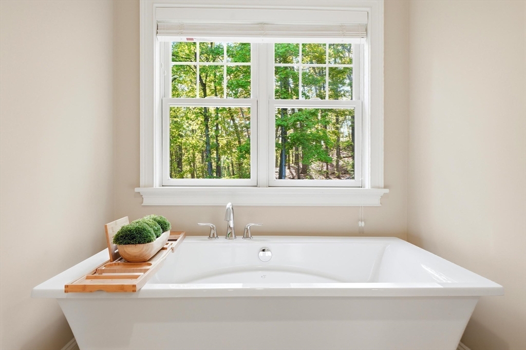 6 Flintlock Road Lexington, MA 02420 - Photo 22 of 39 a white bath tub sitting in a bathroom next to a window