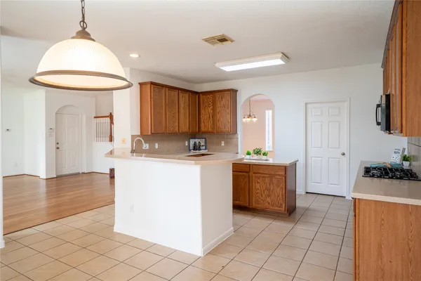 a kitchen with a refrigerator a stove top oven and cabinets