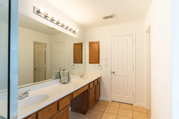 a spacious bathroom with a double vanity sink a mirror and shower