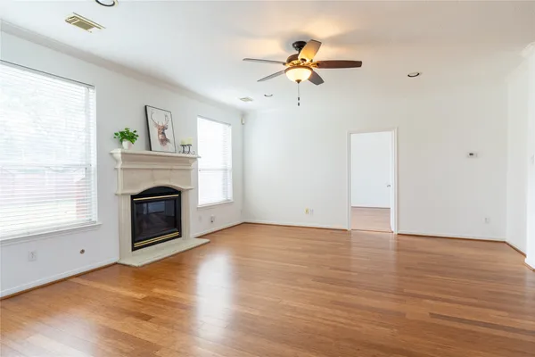 a view of empty room with wooden floor and fireplace