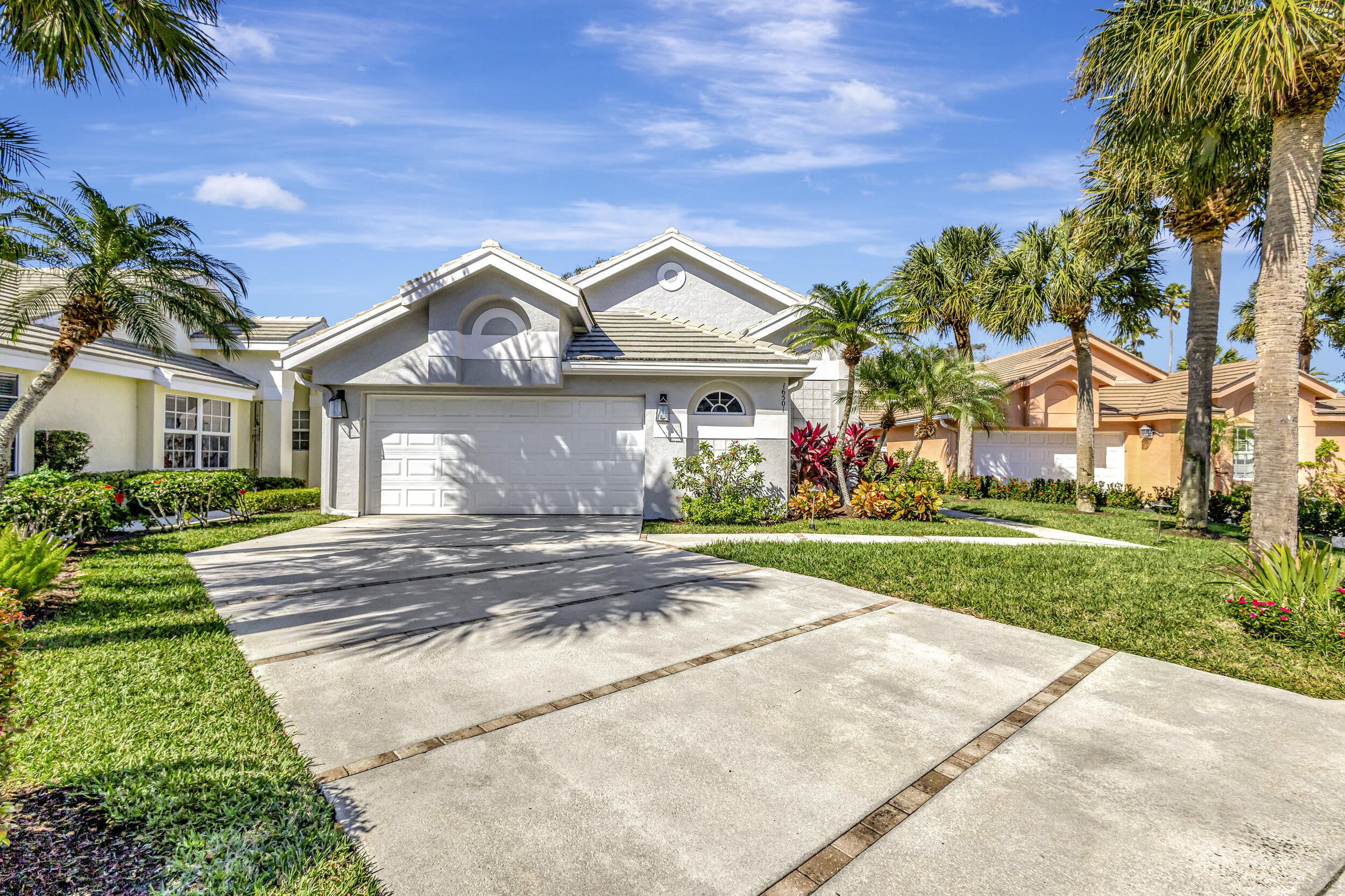 16501 Riverwind Drive Jupiter, FL 33477 - Photo 1 of 50 a front view of house with yard and green space