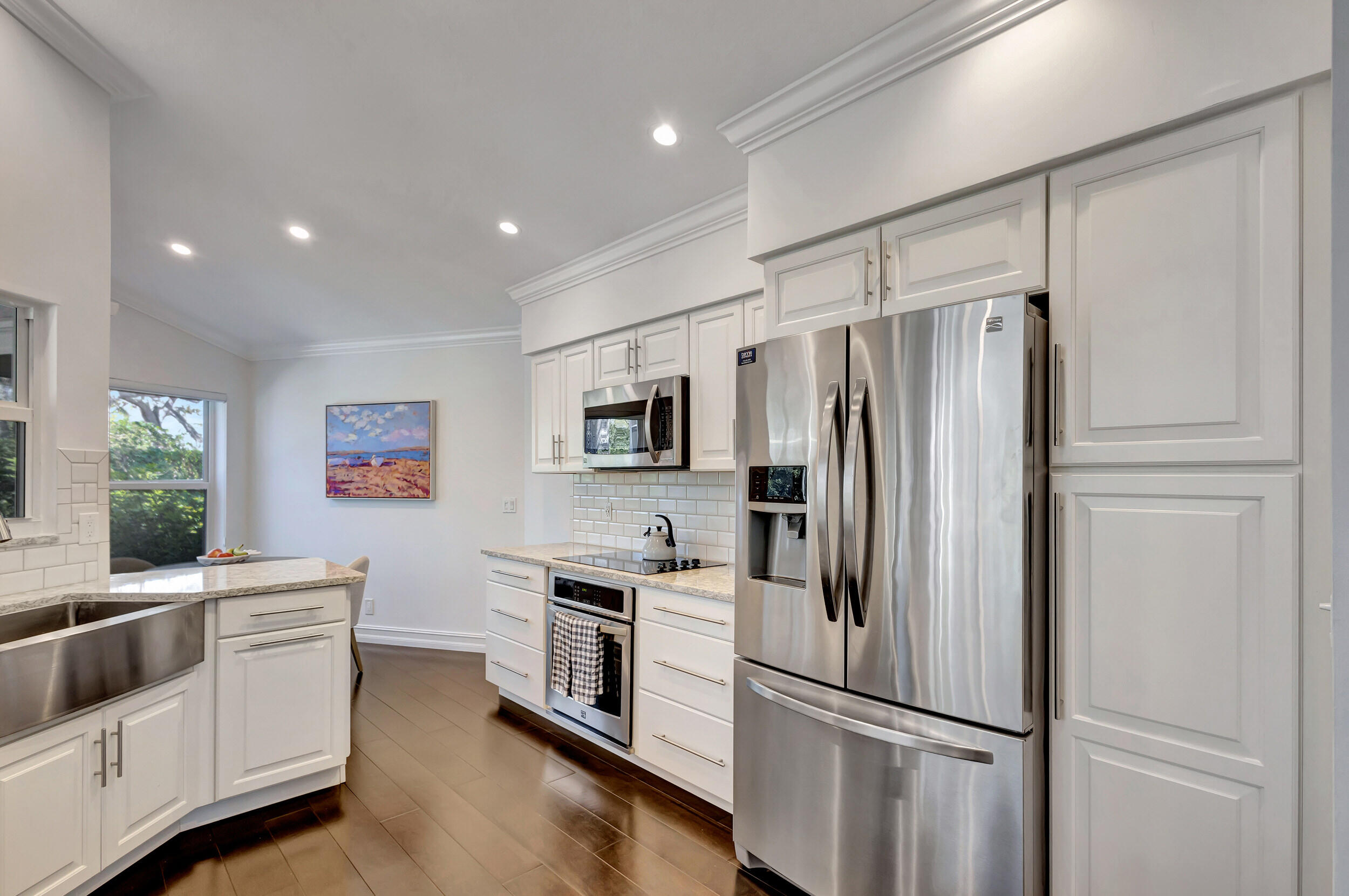 16501 Riverwind Drive Jupiter, FL 33477 - Photo 16 of 50 a kitchen with stainless steel appliances a refrigerator sink and microwave