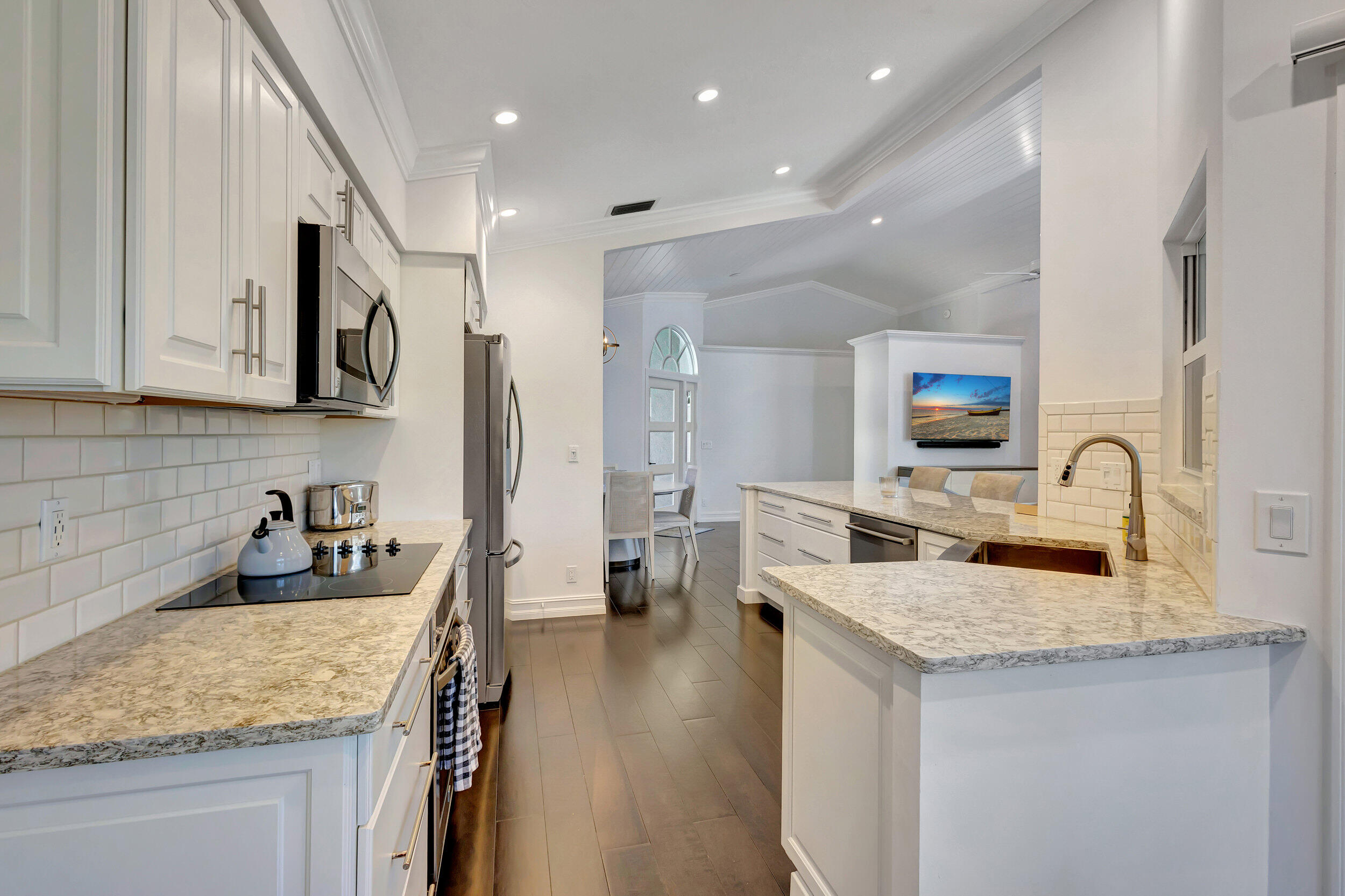 16501 Riverwind Drive Jupiter, FL 33477 - Photo 19 of 50 a kitchen with granite countertop a sink a stove and refrigerator