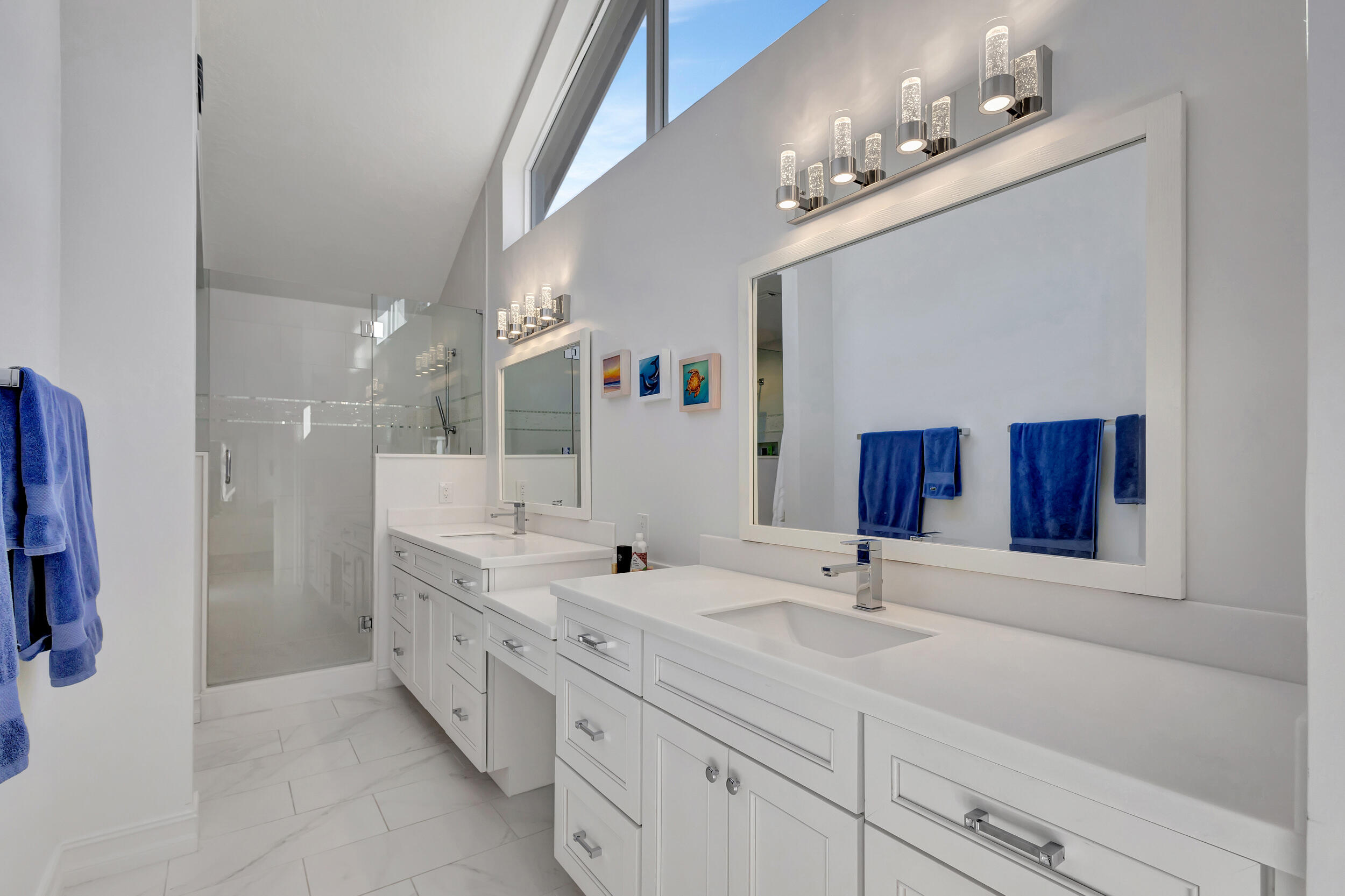 16501 Riverwind Drive Jupiter, FL 33477 - Photo 26 of 50 a bathroom with double vanity sinks a vanity a lamp and a mirror