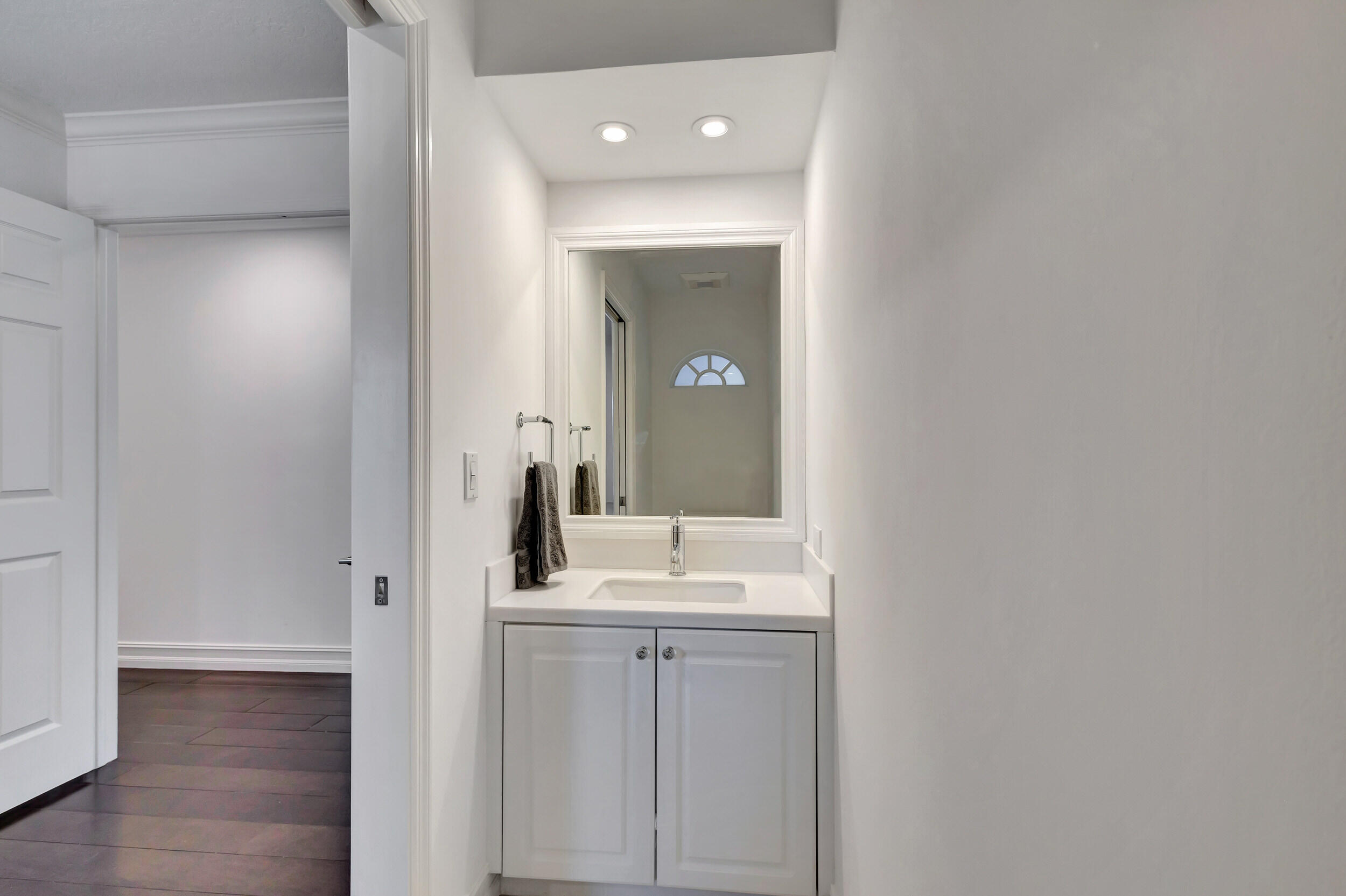 16501 Riverwind Drive Jupiter, FL 33477 - Photo 31 of 50 a bathroom with a granite countertop sink and a mirror