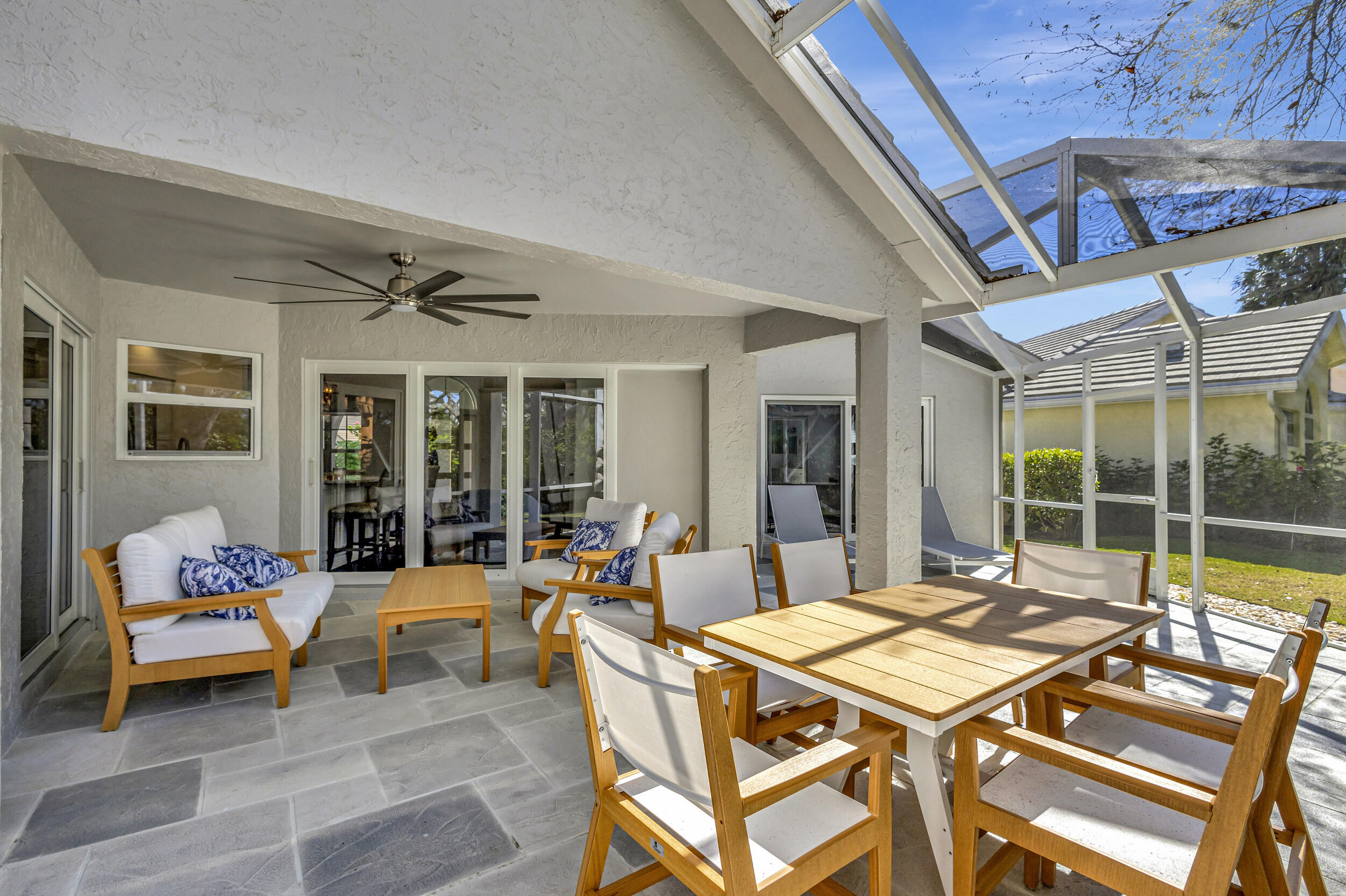 16501 Riverwind Drive Jupiter, FL 33477 - Photo 37 of 50 a view of a patio with a dining table and chairs
