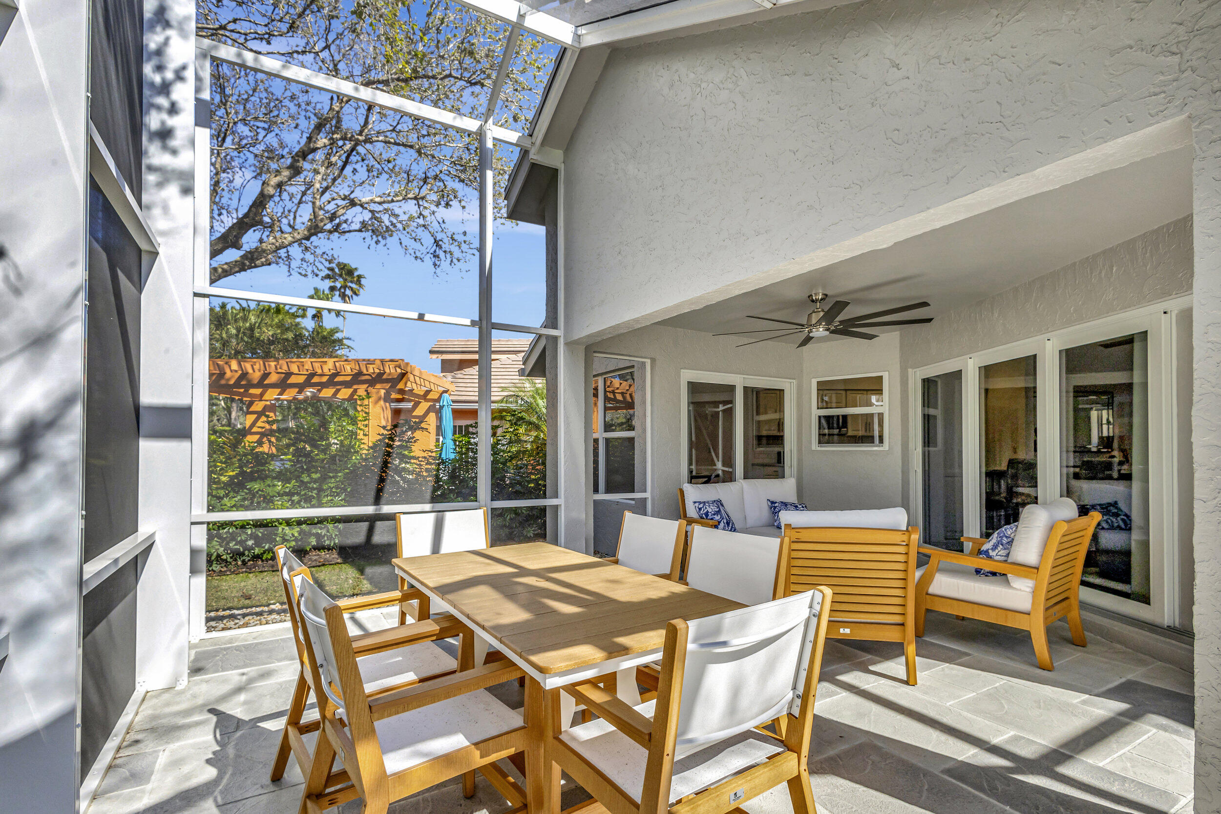 16501 Riverwind Drive Jupiter, FL 33477 - Photo 38 of 50 a view of a patio with a table chairs and a backyard