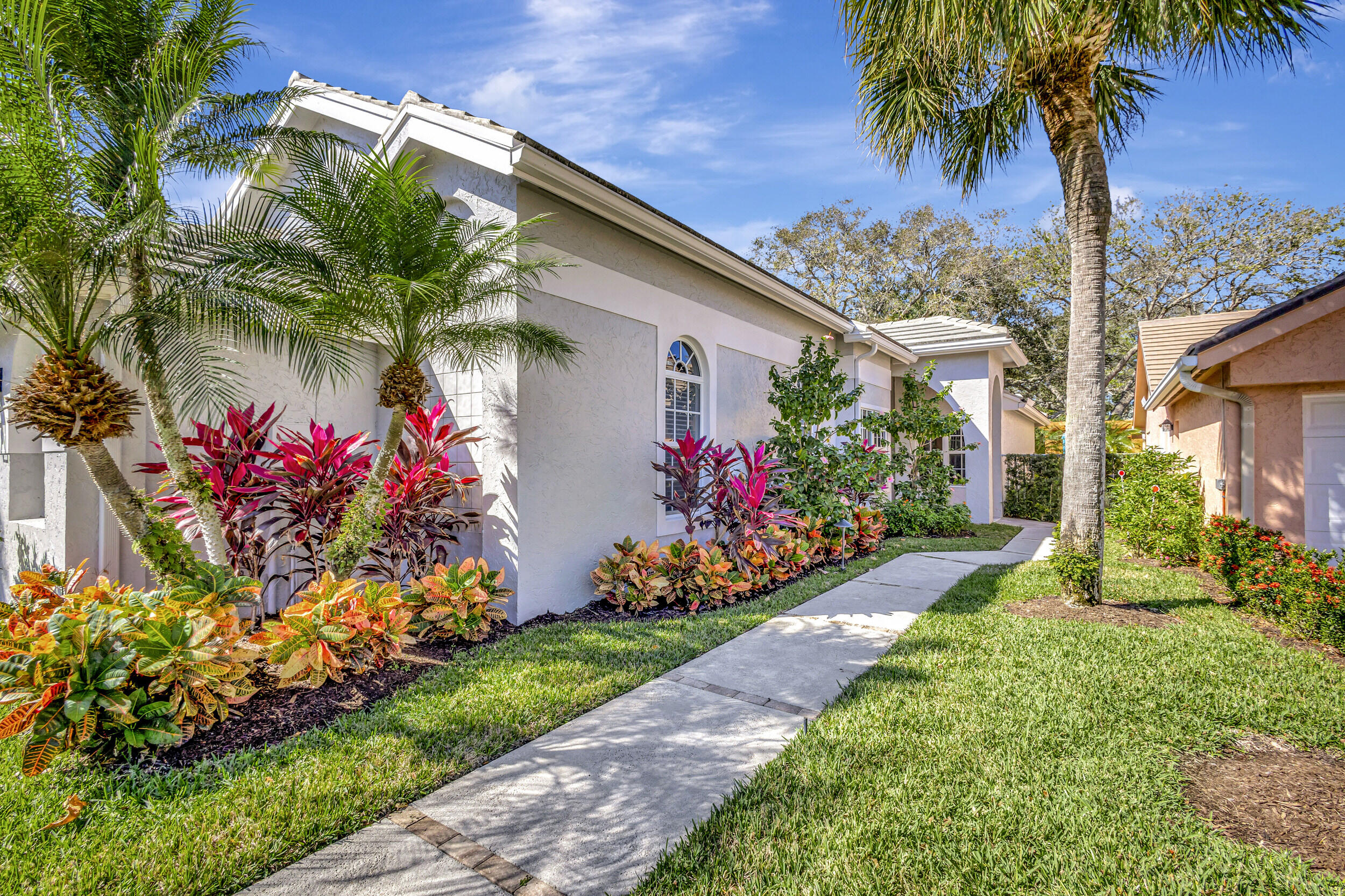 16501 Riverwind Drive Jupiter, FL 33477 - Photo 4 of 50 a front view of a house with a yard and potted plants