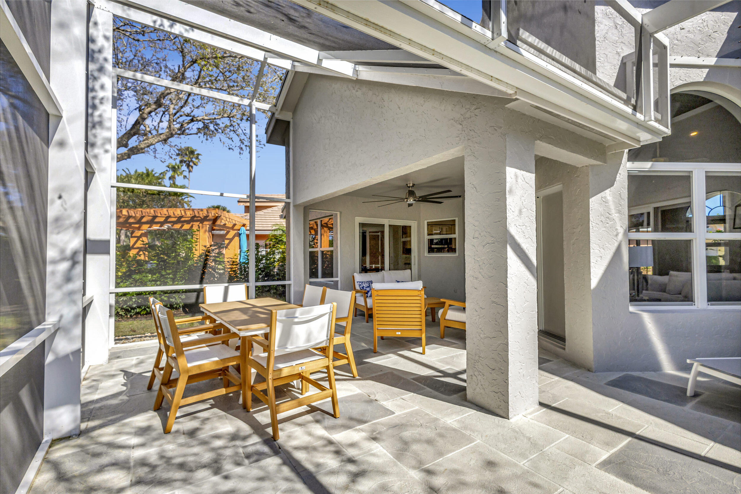 16501 Riverwind Drive Jupiter, FL 33477 - Photo 43 of 50 a view of a patio with table and chairs and floor to ceiling window