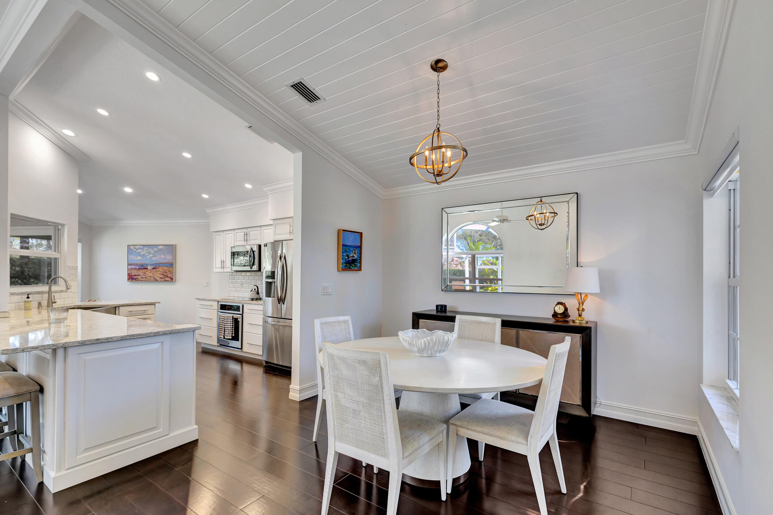 16501 Riverwind Drive Jupiter, FL 33477 - Photo 8 of 50 a view of a dining room and livingroom with furniture wooden floor a chandelier