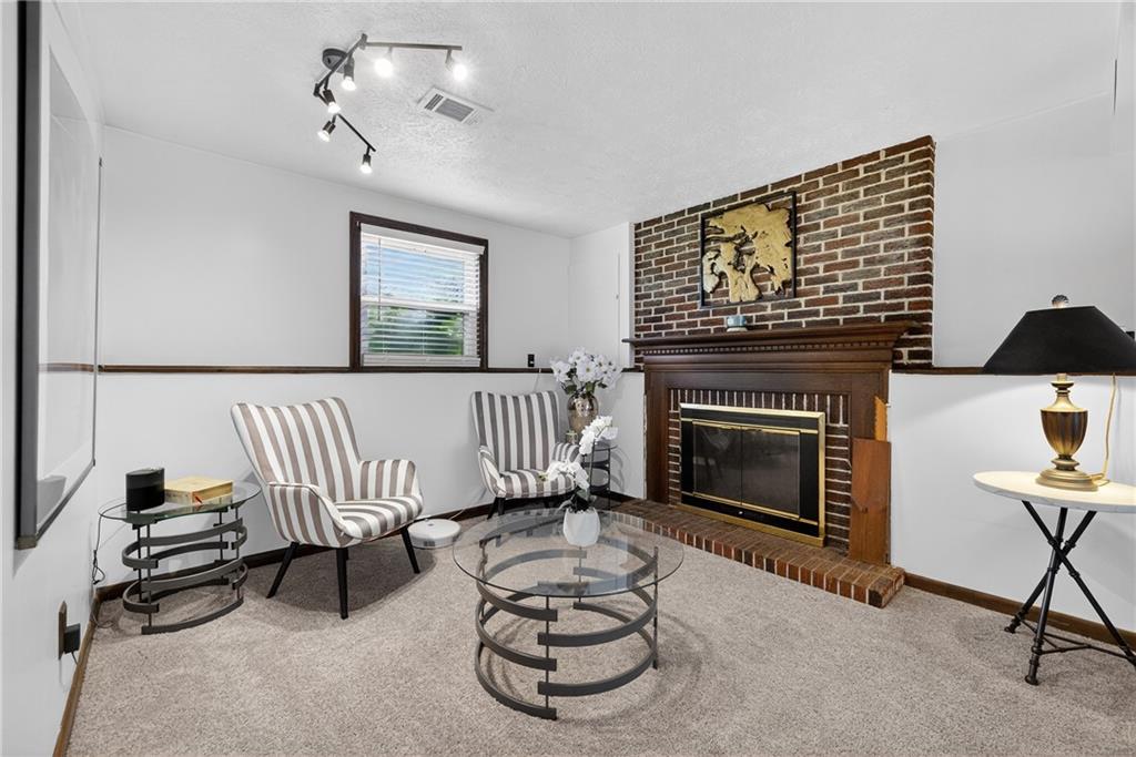 1304 Greenhill Rd Extension Pittsburgh, PA 15209 - Photo 18 of 31 a living room with furniture a fireplace and a flat screen tv