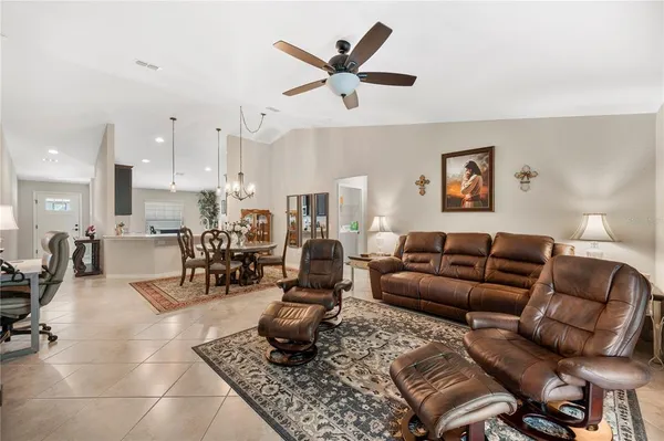 a view of a dining room and livingroom with furniture wooden floor a chandelier