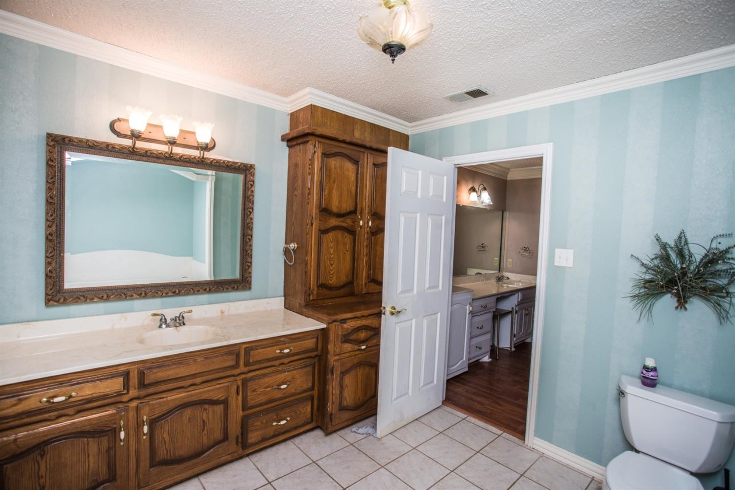 2118 Tech Drive Levelland, TX 79336 - Photo 22 of 42 a en suite bathroom with a granite countertop sink and a mirror