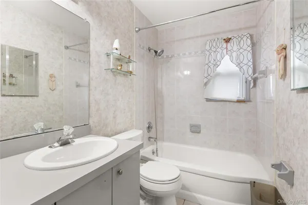 a white toilet sitting next to a bath tub