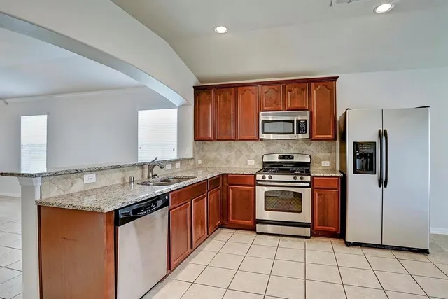 a kitchen with stainless steel appliances granite countertop a sink stove and refrigerator