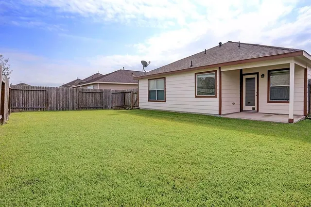 a view of a house with a yard and wooden fence