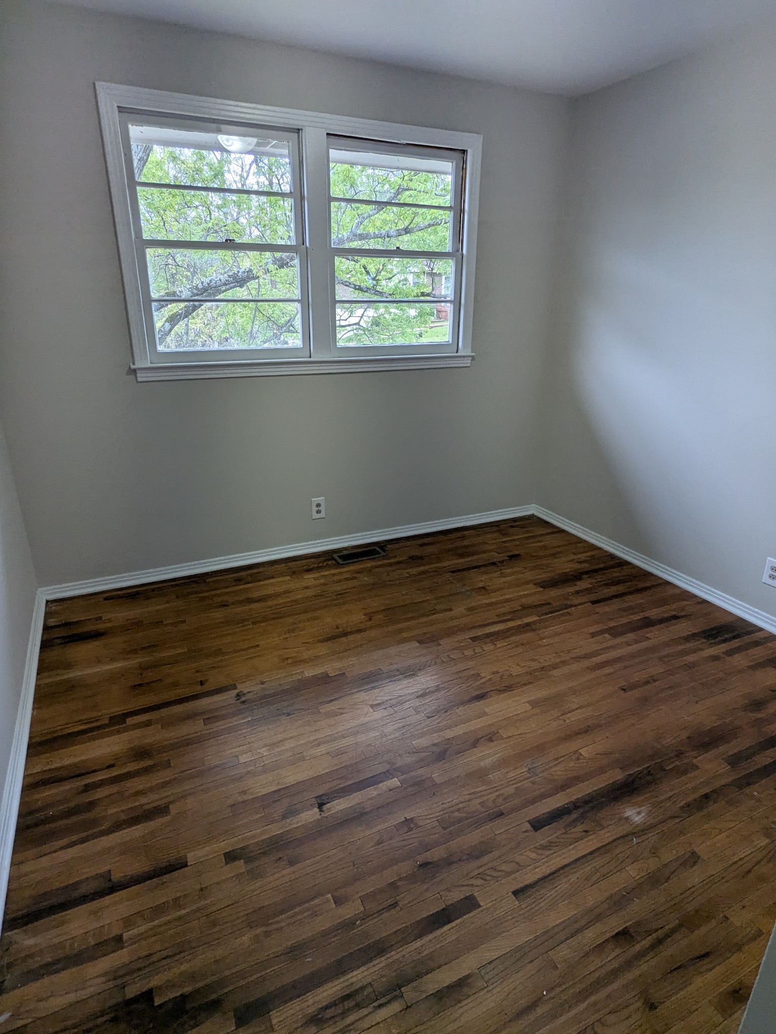 4721 McBride Road Antioch, TN 37013 - Photo 8 of 12 a view of an empty room with wooden floor and a window