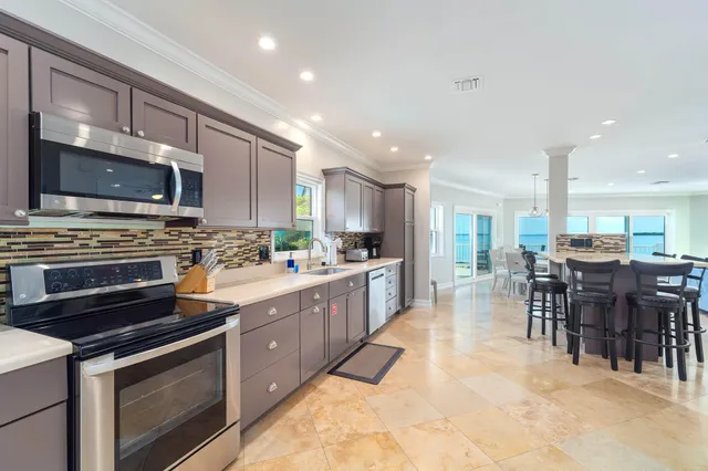 a kitchen with stainless steel appliances granite countertop a stove a sink and a microwave